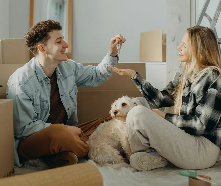A couple unpacking in their new home with their dog