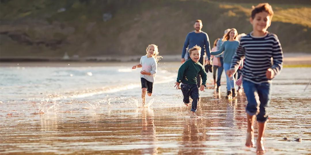 A family running along the beach