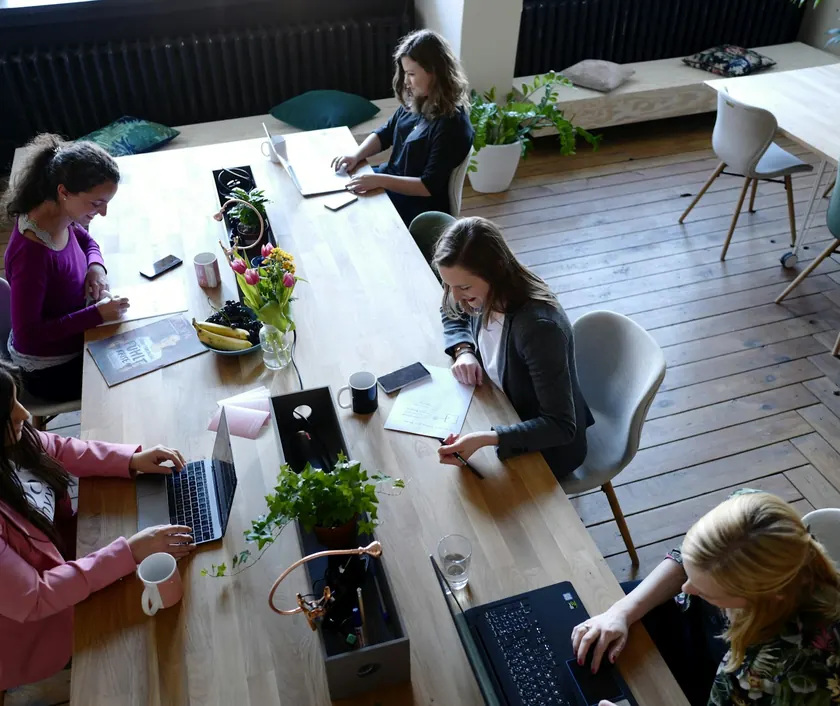 A small team working together around a long table