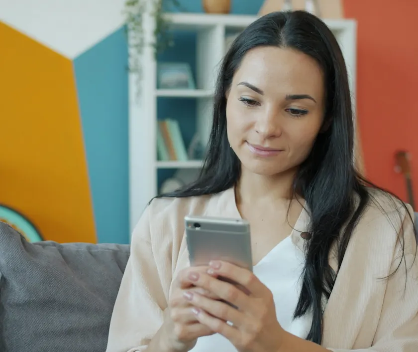 A woman checking her phone at home