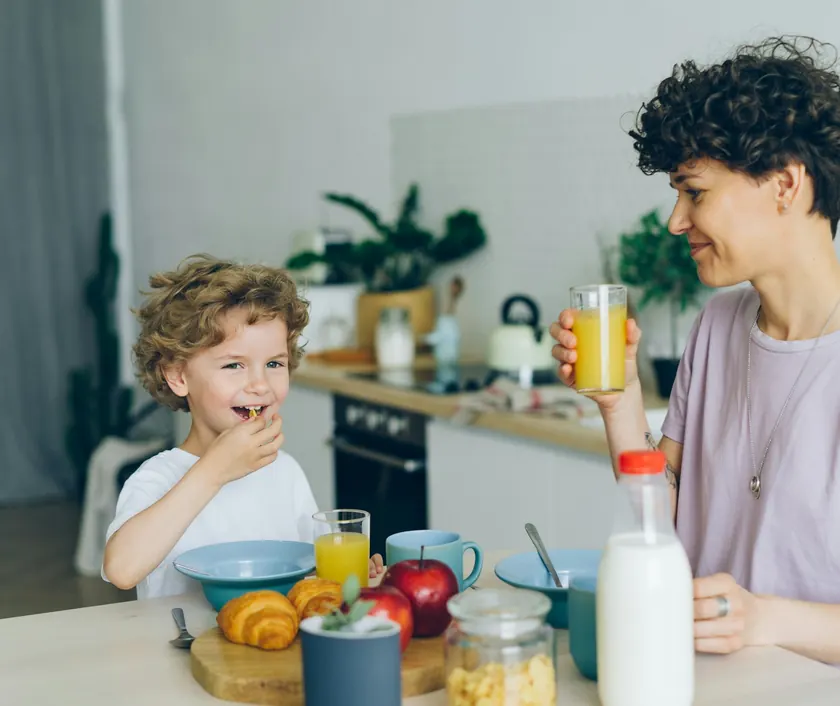 A mother and son having breakfast together in the kitchen