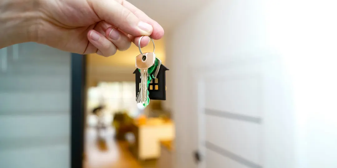 A hand holding up the keys to a new home