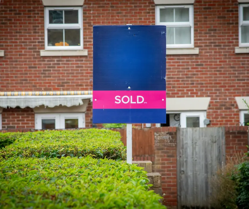A sold sign outside a brick house